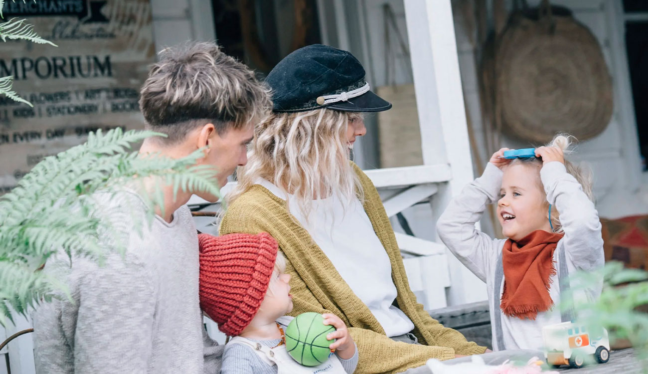 A family relaxes together outdoors, enjoying a playful and relaxed moment. The image reflects everyday life, security, and the importance of protecting what matters most.
