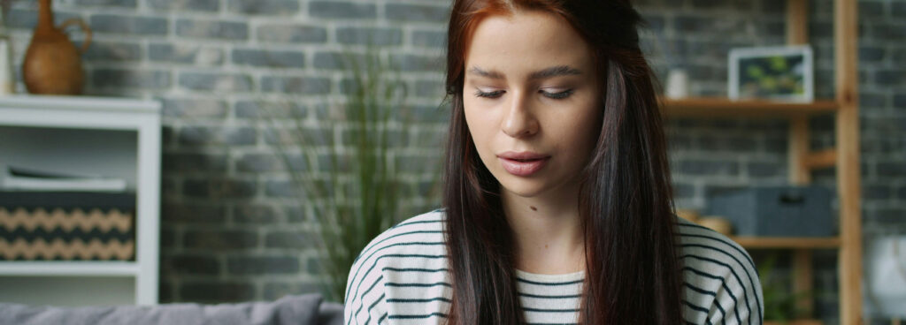 Woman at home checking a credit card while using her smartphone.