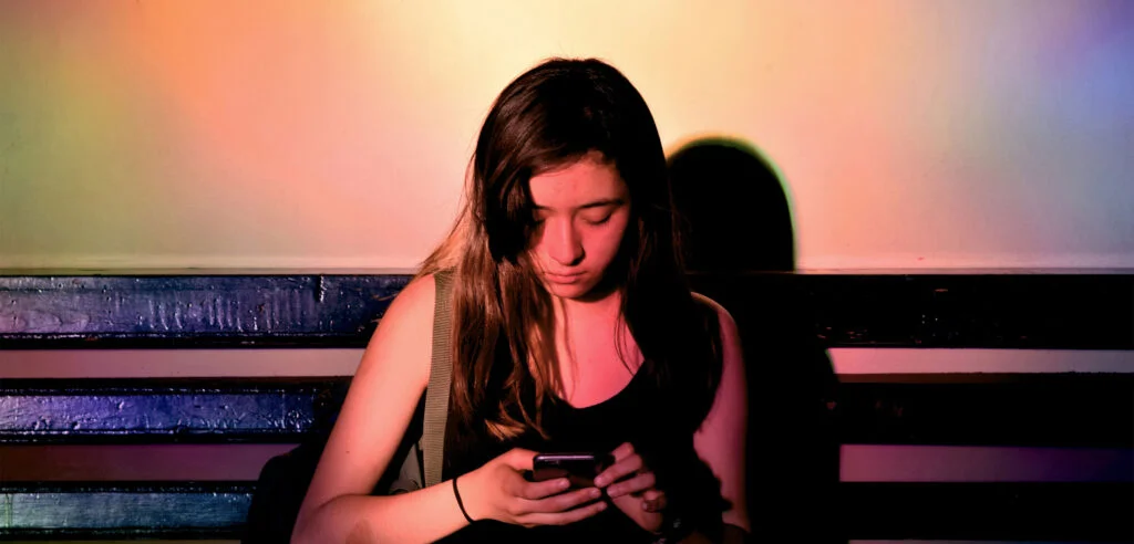 A person using a mobile phone, representing online activity and digital environments.