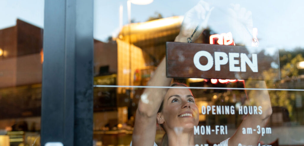 Business owner putting up open sign.
